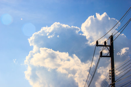 Beautiful clouds and sky with light flare and silhouette electric pole. copy space.の写真素材