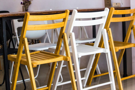 Two brown wood chair and one white wood chair from back.の写真素材