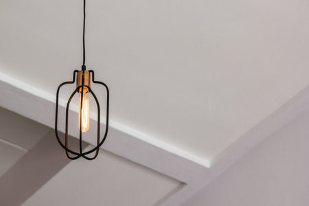 Vintage metal lamp hanging on ceiling. Copy space. Light in cafe.