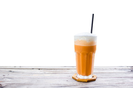 Thai tea iced frappe with cream on wood table on white background.の写真素材