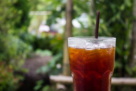 Close up iced coffee and blurred garden background. Americano with copy space.の写真素材