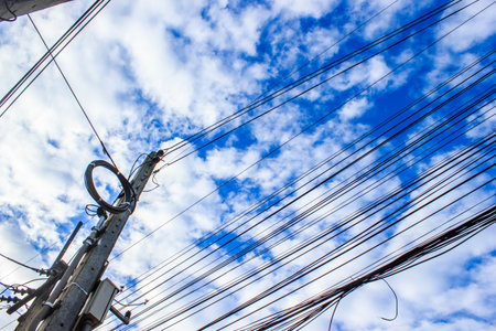 Electric pole from low angle view with blue sky background.の写真素材