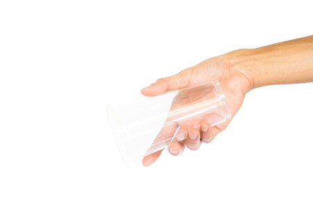 Hand holding plastic cup like a pouring isolated on white background with clipping path.の写真素材