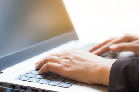 Business woman using laptop checking e-mail or message in office or coffee shop. Laptops are essential in today's work. Portable, convenient to use immediately. Business women an important role today.の写真素材