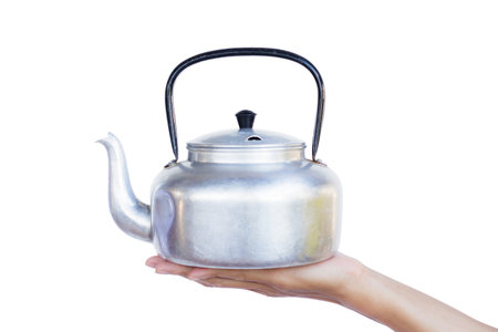 Hand holding Kettle pot isolated on white background . Holding silver Kettle for water or tea....