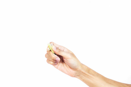 Hand holding chalk writing something text on empty space. Isolated on white background. Chalk is used to write text on a blackboard. Chalk made of plasterの写真素材