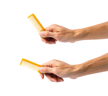 Hand holding comb isolated on white background with clipping path.の写真素材