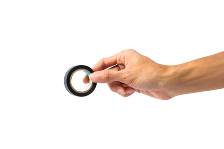Hand holding black plastic tape isolated on white background with clipping path.の写真素材