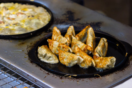 Nice to eat fried Dumplings on hot black pan. Ready to eat. Asian food background.の写真素材