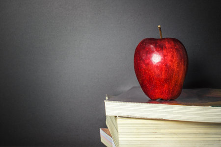 Red apple on book with Blackboard (Chalk Board) as background with copy space. Education and Back to school concept.の写真素材