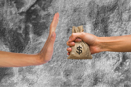 A hands holding money bag and rejecting hand to receive money of another person on concrete wall background. Conceptual stop corruption. Corruption reject concept.の写真素材
