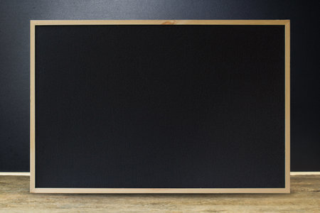 Clean black chalkboard texture with wooden frame on wood table for background. Black to school concept. advertising, sale.の写真素材