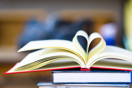 Love to reading books concept : Stack of books and open book heart shape on the table. Library,...