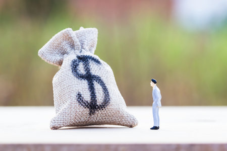 Money investment. Savings money concepts. A figure man standing looking and thinking about what to do with this money. Growing money for business future.の写真素材