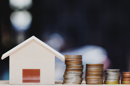 Property investment, home loan, house mortgage, resident financial concept. Stacking coins in 1 to 3 step with small house on table over green nature background. Demonstrate growth of real estate.の写真素材