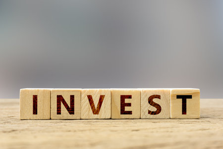 Investment concept. Wooden block with text on wood table and space.