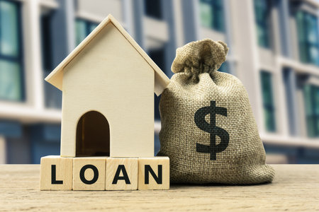 Home loan, mortgage, home insurance, financial mortgage for house concept. A dollar money in bag and residential model on a wooden block. Depicts borrow sum of money or savings for item of a property.の写真素材