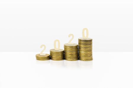 Money saving and investment in year 2020 concept. Wooden number on stack of coins on white...