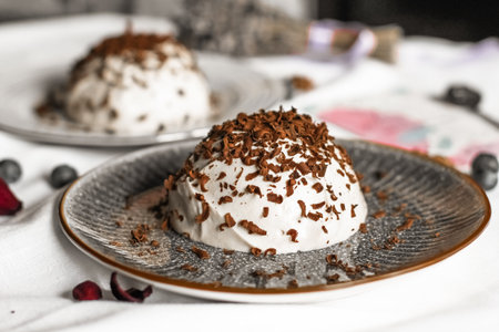 Vanilla Panna Cotta with chocolate flakes on gray plate on white tablecloth background. Close-up view. Healthy dessert without sugar.の写真素材