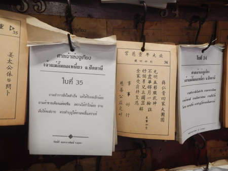 fortune teller papers were stick on the wall at shrine, Thailandのeditorial素材