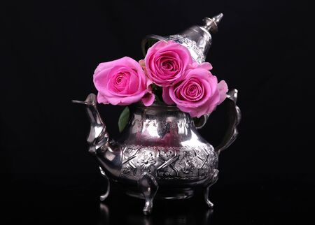 Teapot with pink rosesの写真素材