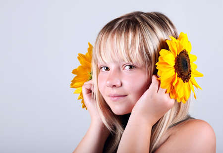 A beautiful happy girl holding a sunflowerの写真素材