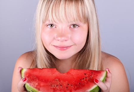 Beautiful  girl eating a juicy slice of watermelonの写真素材