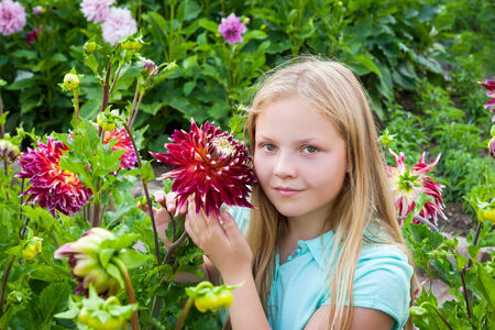 Portrait of young girl with flowers in the gardenの写真素材