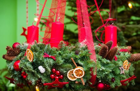 Christmas decoration evergreen wreath decorated with red candlesの写真素材