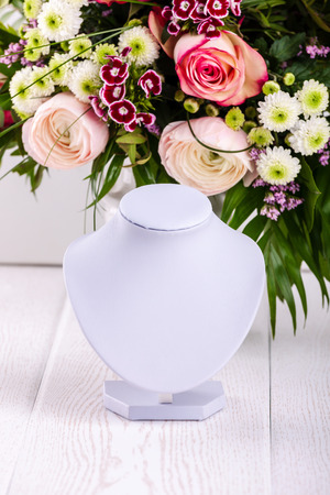 Necklace display on floral backgroungの写真素材