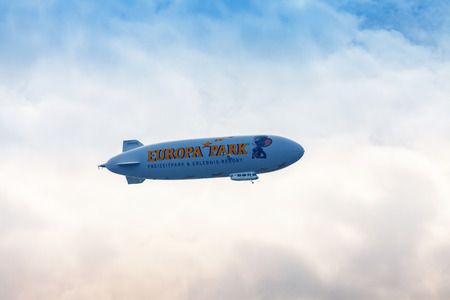 MAINAU, GERMANY - APRIL 15, 2018: Blue dirigible flying in cloudy sky, Lake Constance,...