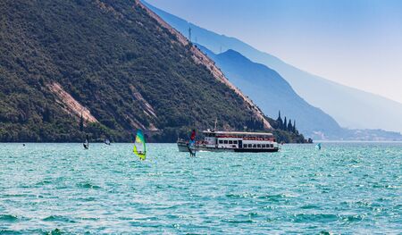 Nago Torbole, Lago di Garda (Lago Benaco), Italy - June 18, 2019. A windsurfing on Lake Garda in Torbole resort. Recreational Water Sports.のeditorial素材