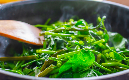 Hot and fresh Pad Pak-boong,Stir-Fried Swamp Cabbage with Salted Soya Bean, a famous Thai and Chinese's food in a cooking pan.の写真素材