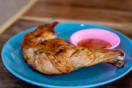 Roast chicken leg or chicken grilled BBQ in blue plate with sweet sauce.の写真素材