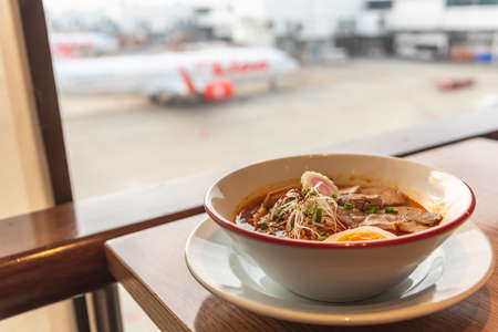 Ramen a famous Japanese food noodle in hot soup with airplane view at airport lounge ramen restaurant.の写真素材