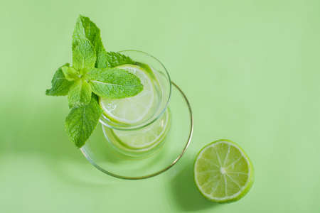 tea with mint and lime, with a calming effect, green still life close-up on a green background, top view. mojito, health drink, alternative medicineの写真素材