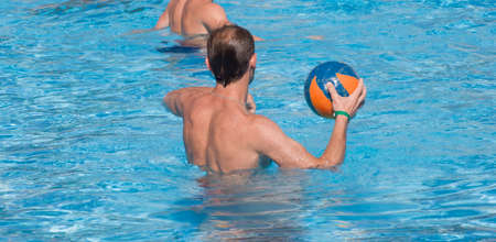 A young guy from the back throws a ball in the pool ofの写真素材