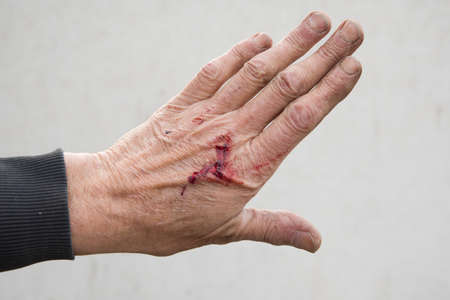 bloody and dirty left hand of a working man from the backの写真素材