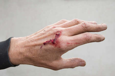 bloody and dirty left hand of a working man from the backの写真素材