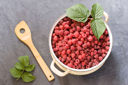 a full pan of ripe raspberries and a spoon for jam, a large harvest of healthy berries, a healthy diet. Favorite delicacy, preservation of Natural vitamins for the winterの写真素材