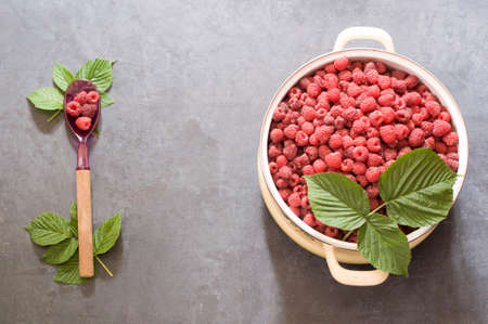 a full pan of ripe raspberries and a spoon for jam, a large harvest of healthy berries, a healthy diet. Favorite delicacy, preservation of Natural vitamins for the winterの写真素材