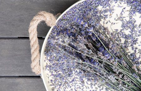dry lavender on a beige tray on a wooden table top viewの写真素材