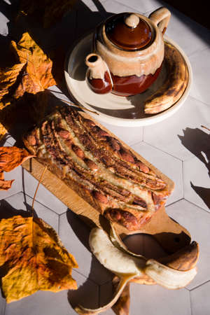 Still life Banana pie with a ceramic teapot in the rays of the autumn sunの写真素材