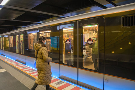 Brussels, Belgium - 01.31.2022 A young woman enters a subway car in a big city