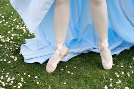 ballerinas legs in pointe shoes on a green flowering lawn in early springの写真素材