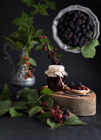 a jar of blackberry jam and bruschettas with soft cheese and berries