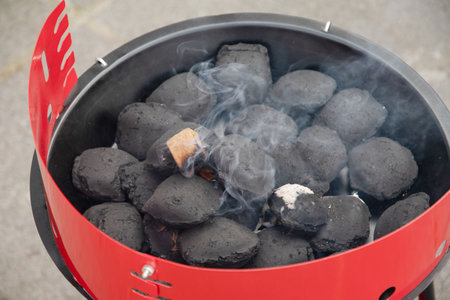 a man lights a fire with a lighter special charcoals for a barbecueの写真素材