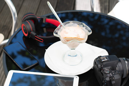 tables in a cafe melted ice cream in bowl near the phone headphones and a tablet