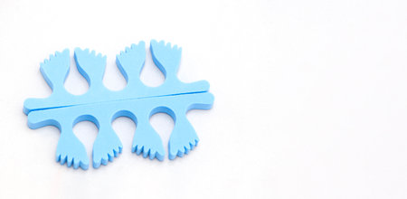 A pair of blue toe separators in the form of small feet,isolated with copy space