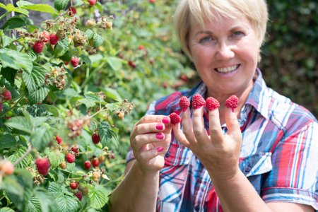 a woman put raspberries on her fingers and shows her original berry manicure